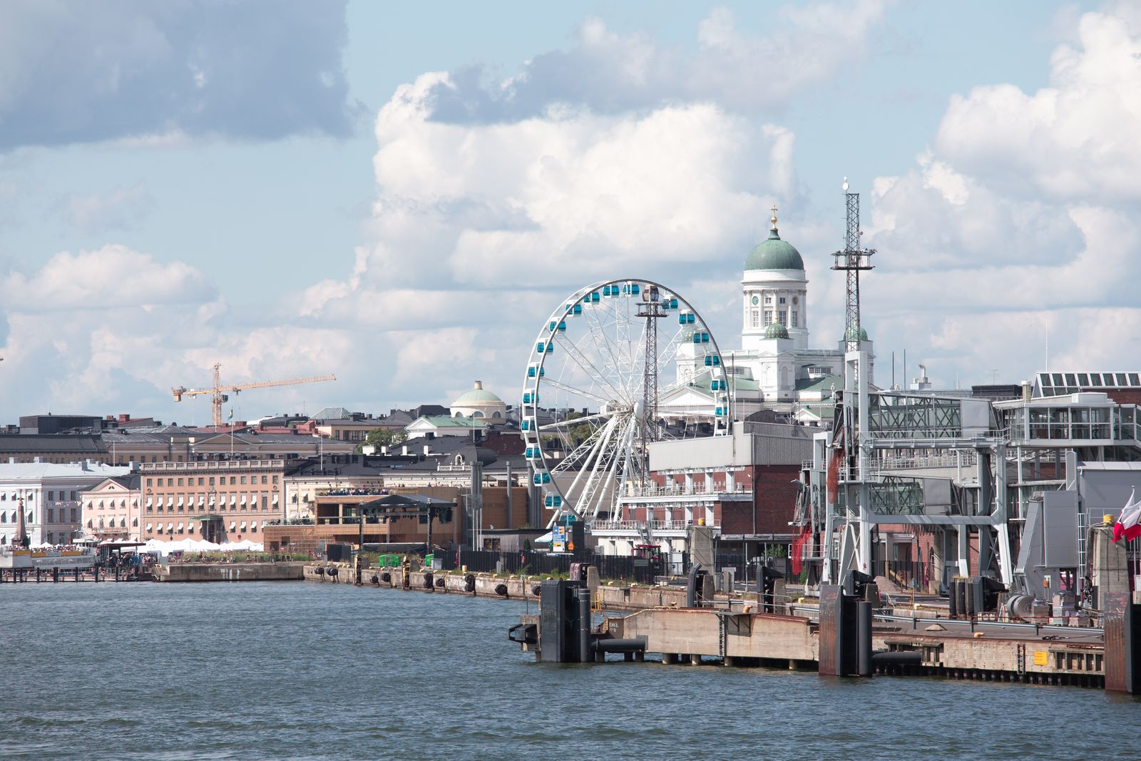 Scenic Helsinki waterfront featuring the Sky Wheel and iconic Helsinki Cathedral.